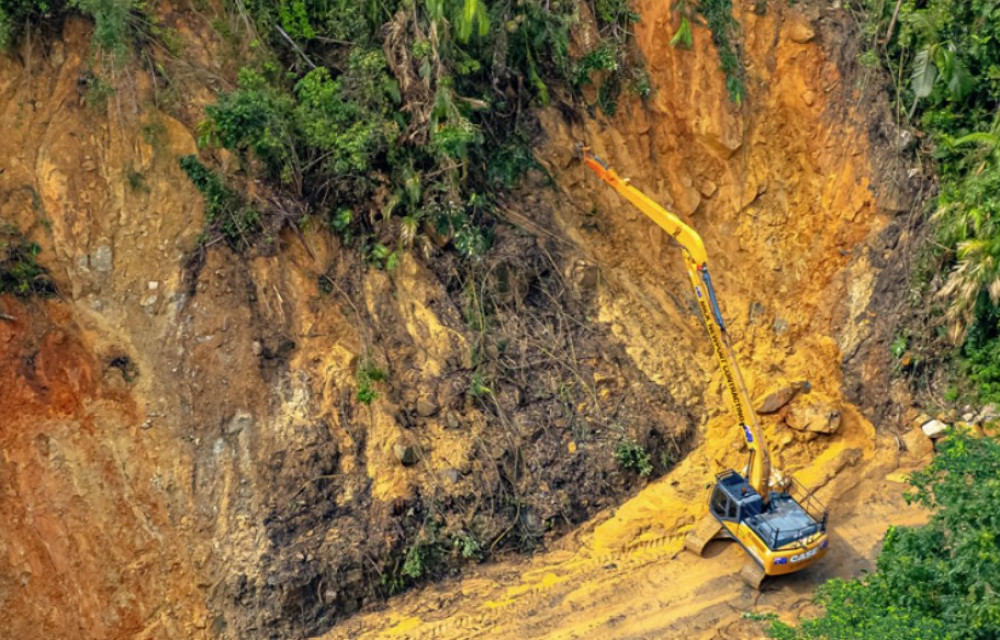 Construction team stabilising steep landslip site on Mount Spec Road with soil nails and shotcrete under cloudy North Queensland sky